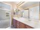 Bathroom featuring a double sink vanity, neutral color palette, and view to the bedroom at 11238 Meadow Cove St, Las Vegas, NV 89179