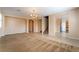 Open living room featuring neutral walls, carpet, and tile flooring with an adjoining kitchen and staircase at 11238 Meadow Cove St, Las Vegas, NV 89179