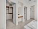 Bright primary bathroom featuring walk-in closet, large tub, and vanity at 1155 Phillip Island St, Henderson, NV 89052