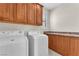 This laundry room features wood cabinets and appliances, offering practicality and storage at 1155 Phillip Island St, Henderson, NV 89052