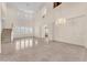 Expansive living room with tile flooring, grand staircase, large windows, and a modern chandelier at 1155 Phillip Island St, Henderson, NV 89052