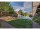 Lush green backyard featuring a pristine pool, stone retaining wall, and mature landscaping at 11952 Girasole Ave, Las Vegas, NV 89138