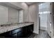 Bathroom with granite double vanity, dark wood cabinets, and access to a tiled tub/shower combo at 11952 Girasole Ave, Las Vegas, NV 89138