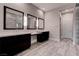 Spacious bathroom featuring double vanities and three decorative mirrors at 11952 Girasole Ave, Las Vegas, NV 89138