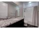 Bathroom with granite countertop, large mirror, and white tile shower provides a sleek aesthetic at 11952 Girasole Ave, Las Vegas, NV 89138