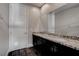 Bathroom with granite double vanity, dark wood cabinets, modern fixtures, and hardwood floors at 11952 Girasole Ave, Las Vegas, NV 89138
