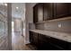 Hallway with dark wood cabinets, granite counters, and a mosaic backsplash, complemented by stainless appliances at 11952 Girasole Ave, Las Vegas, NV 89138