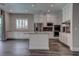 This open kitchen features stainless appliances, island, and custom white cabinetry at 11952 Girasole Ave, Las Vegas, NV 89138