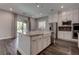 This open kitchen features stainless appliances, an island, and white cabinets at 11952 Girasole Ave, Las Vegas, NV 89138