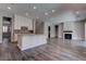 Open living space featuring a kitchen with island, adjacent to a living room with fireplace and a staircase at 11952 Girasole Ave, Las Vegas, NV 89138