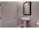 This powder room features a pedestal sink, decorative mirror, and neutral paint at 11952 Girasole Ave, Las Vegas, NV 89138