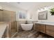 Elegant bathroom featuring a standalone tub, a glass-enclosed shower, and modern vanities at 1309 Vista Del Monte Dr, Mesquite, NV 89027