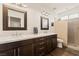 Modern bathroom with double sinks, marble countertop, dark wood cabinets, and a tiled shower at 1309 Vista Del Monte Dr, Mesquite, NV 89027