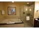 A bathroom featuring a bathtub and glass-door shower at 145 E Harmon Ave # 27619, Las Vegas, NV 89109