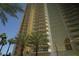 Exterior view of a modern high-rise building with balconies and lush palm trees at 145 E Harmon Ave # 27619, Las Vegas, NV 89109