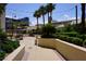 Courtyard walkway and surrounding palm trees with building and blue sky above at 145 E Harmon Ave # 27619, Las Vegas, NV 89109