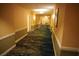 Hallway with patterned carpet and warm color walls lead to different doors at 145 E Harmon Ave # 27619, Las Vegas, NV 89109