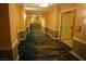 Long hallway with patterned floor designs and multiple doors along the way at 145 E Harmon Ave # 27619, Las Vegas, NV 89109