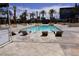 Tranquil pool area with palm trees, lounge chairs, and clear blue water at 145 E Harmon Ave # 27619, Las Vegas, NV 89109
