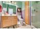 Bathroom with a tiled walk-in shower, wooden vanity, and unique wall decor at 1632 Royal Canyon Dr, Las Vegas, NV 89128