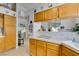Kitchen with wood cabinets, white tile countertops, view into dining area, and tile flooring at 1632 Royal Canyon Dr, Las Vegas, NV 89128