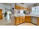 Bright kitchen with white countertops, wood cabinets, stainless steel appliances, and a garden window at 1632 Royal Canyon Dr, Las Vegas, NV 89128