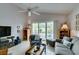 Bright living room with a ceiling fan, tile floors, and access to an outdoor patio at 1632 Royal Canyon Dr, Las Vegas, NV 89128
