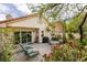 Charming backyard patio with a seating area, lounge chairs, mature trees, and lush landscaping, ideal for outdoor gatherings at 1632 Royal Canyon Dr, Las Vegas, NV 89128
