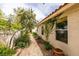 Picturesque side yard with gravel pathway, greenery, and a view of the home's exterior with climbing vines at 1632 Royal Canyon Dr, Las Vegas, NV 89128