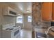A cozy kitchen features tile flooring and an older model white range oven beneath an overhead microwave at 240 N 19Th St, Las Vegas, NV 89101