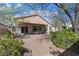Serene backyard with gravel landscaping, mature trees, and a covered patio with outdoor seating at 2467 Moonlight Valley Ave, Henderson, NV 89044