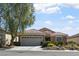 Attractive single-story home showcasing a well-maintained yard, stone accents, and an attached garage at 2467 Moonlight Valley Ave, Henderson, NV 89044