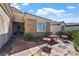 Inviting home exterior with stone facade, a cozy front patio seating area, and a decorative front door at 2467 Moonlight Valley Ave, Henderson, NV 89044