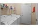 Bright laundry room featuring modern washer and dryer appliances and shelving at 2467 Moonlight Valley Ave, Henderson, NV 89044