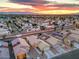 Sunset aerial view of community showcasing homes with solar panels, with mountain views in the distance at 2595 Amber Crest St, Las Vegas, NV 89142