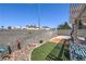Enclosed backyard features concrete block wall, low maintenance turf, covered patio with lounge seating at 2595 Amber Crest St, Las Vegas, NV 89142