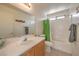 Bathroom with a large vanity, framed mirror, shower-tub combo, and neutral tile floors at 2595 Amber Crest St, Las Vegas, NV 89142