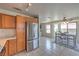 Eat-in kitchen with stainless steel appliances, tile flooring, and wood cabinets; table next to large windows at 2595 Amber Crest St, Las Vegas, NV 89142