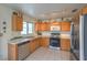 Bright kitchen featuring stainless steel appliances, tile flooring, and wooden cabinets with ample counter space at 2595 Amber Crest St, Las Vegas, NV 89142