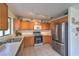 Traditional kitchen featuring stainless steel appliances, tile flooring, and wooden cabinets providing ample storage at 2595 Amber Crest St, Las Vegas, NV 89142