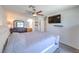Inviting main bedroom with a soft, tufted headboard, ceiling fan, dresser and view to ensuite bath at 2595 Amber Crest St, Las Vegas, NV 89142