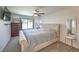 Inviting main bedroom with a soft, tufted headboard, ceiling fan, and large window for natural light at 2595 Amber Crest St, Las Vegas, NV 89142