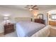 Inviting main bedroom with a soft, tufted headboard, ceiling fan, and dresser with mirror at 2595 Amber Crest St, Las Vegas, NV 89142