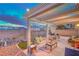 Relaxing covered patio with comfortable seating, a grill, and a view of the landscaped backyard at 2595 Amber Crest St, Las Vegas, NV 89142