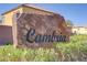 Stone 'Cambria' community sign surrounded by desert foliage and neighborhood buildings under a bright, clear sky at 320 Point Loma Ave, North Las Vegas, NV 89031