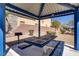 Covered picnic area with charcoal grill and large picnic table near desert landscaping and residential buildings at 320 Point Loma Ave, North Las Vegas, NV 89031