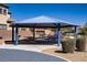 Exterior of a covered picnic pavilion with tables and grills, surrounded by desert landscaping and community features at 320 Point Loma Ave, North Las Vegas, NV 89031