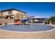 Community playground with a red slide, blue tunnels, and covered picnic tables on a blue safety surface at 320 Point Loma Ave, North Las Vegas, NV 89031