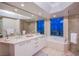 Lavish bathroom with dual sinks, soaking tub, walk-in shower, and skyline view at 322 Karen Ave # 2807, Las Vegas, NV 89109