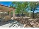 Private backyard with a covered patio, mature trees, and rock landscaping at 4487 Tomer Ln, Las Vegas, NV 89121